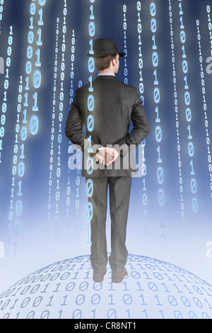Businessman standing on binary globe with binary strings Stock Photo