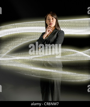 Businesswoman looking at data streams Stock Photo