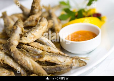 Fried fresh sprat fish with souce. Good seafood. Stock Photo
