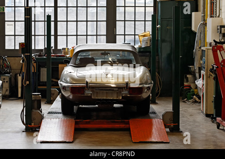 Jaguar Type E on a hoist, vintage car workshop, Meilenwerk Duesseldorf, Duesseldorf, North Rhine-Westphalia, Germany, Europe Stock Photo