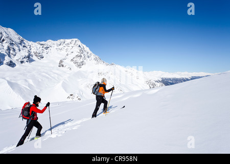 Cross-country skiers during the ascent to the rear of Schoentaufspitze Mountain, Solda in winter, in front of the Ortler Range Stock Photo