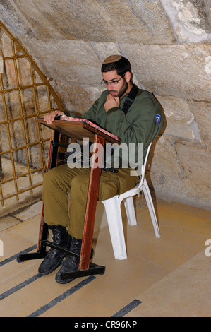 Praying Jewish soldier in the underground part of the Western Wall, Wailing Wall, Old City, Arab Quarter, Jerusalem, Israel Stock Photo