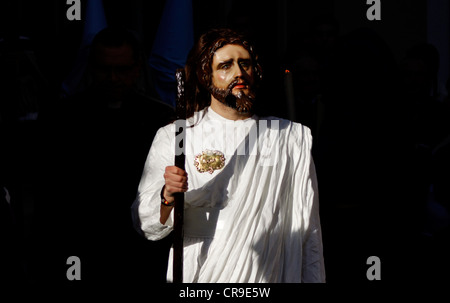 A masked man dressed as Jesus Christ walks in a street during an Easter Holy Week procession in Puente Genil, Spain Stock Photo