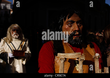 Masked men dressed as biblical characters walk in a street during an Easter Holy Week procession in Puente Genil, Spain. Stock Photo