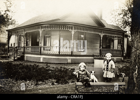 Little Brother & Sister in front of Victorian Bungalow with Dog Stock Photo