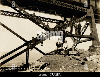 Construction Workers Perching on Steel Beams Below Bridge Stock Photo