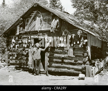 Eccentric Old Man Hoarder in front of Log Cabin Stock Photo