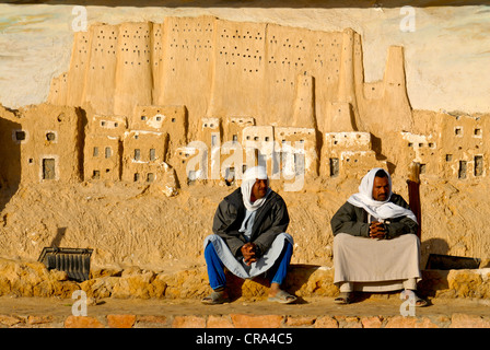 Two talking men in front of a copy of the Shali in Siwa, Egypt, Africa Stock Photo