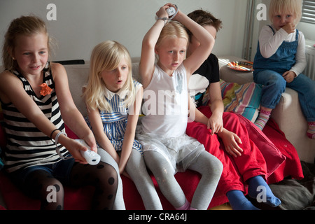 Group of children playing a Nintendo Wii Game Console at home. Stock Photo