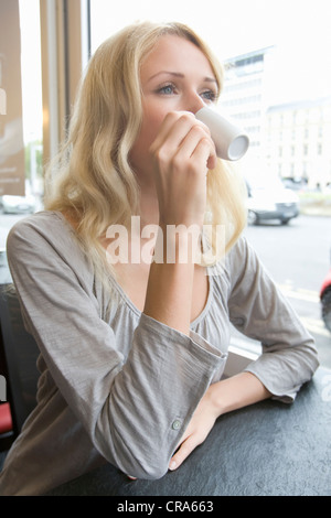 Woman drinking cappuccino in cafe Stock Photo