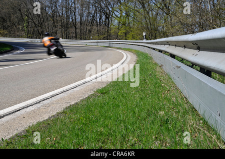 Motorcyclist in a curve on a country road with guard rail for protection, Eifel, Germany, Europe Stock Photo