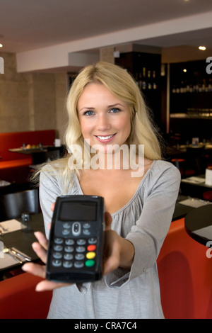 Hostess offering credit card machine Stock Photo