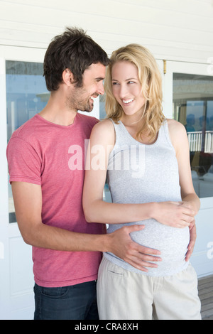 Man holding pregnant girlfriends belly Stock Photo