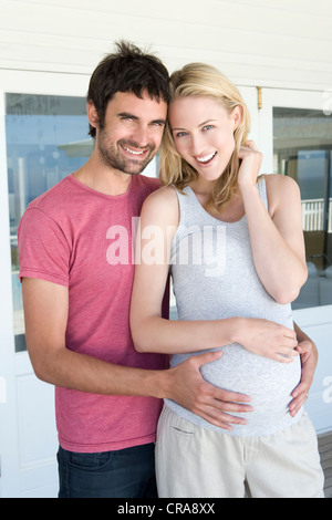 Man holding pregnant girlfriends belly Stock Photo