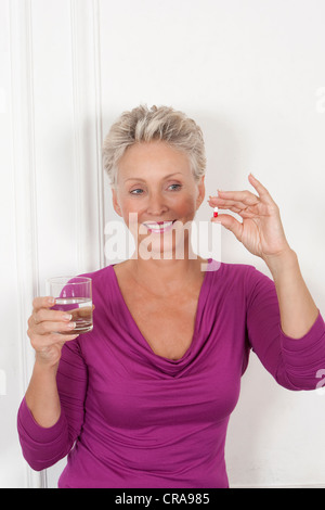 Older woman taking medication Stock Photo