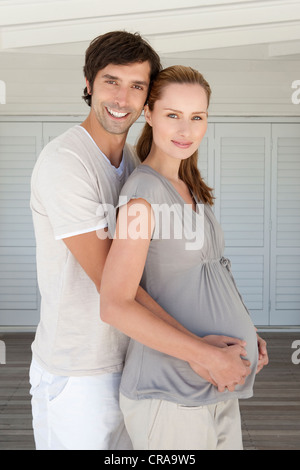 Man holding pregnant girlfriends belly Stock Photo