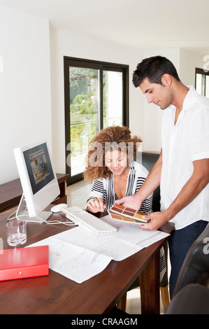 Couple examining swatches at desk Stock Photo