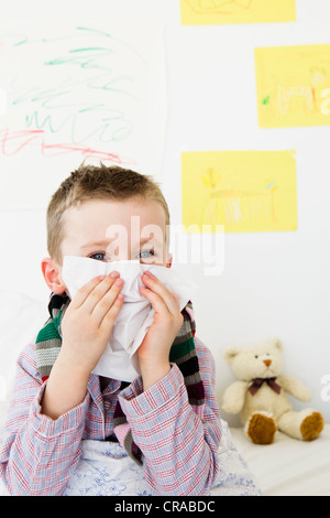 Boy wiping his nose in bed Stock Photo