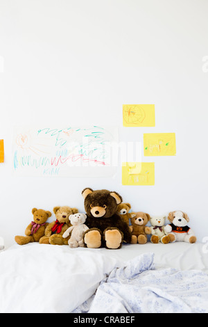 Teddy bears and childs drawings on bed Stock Photo