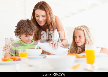Mother pouring milk for son Stock Photo