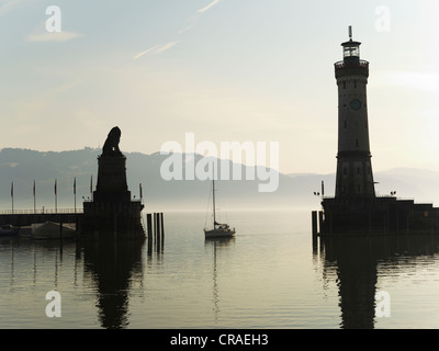 Harbour entrance of Lindau, back lit, with the Bavarian lion and the lighthouse of Lindau, Lake Constance, Swabia, Bavaria Stock Photo