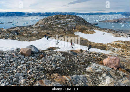 Group of hikers with a guide, icebergs near Tiniteqilaaq, Ammassalik Peninsula, at Sermilik Fjord, East Greenland, Greenland Stock Photo