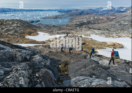 Group of hikers with a guide, icebergs near Tiniteqilaaq, Ammassalik Peninsula, at Sermilik Fjord, East Greenland, Greenland Stock Photo