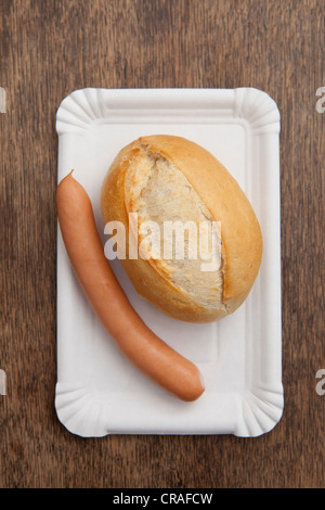 Roll with sausage on paper plate, fast food Stock Photo