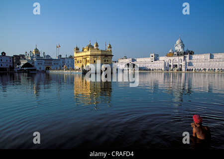 Sikh man taking a holy bath in Amrit Sagar, 'Lake of Nectar', Golden Temple, Amritsar, Punjab, North India, India, Asia Stock Photo