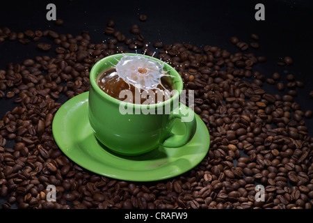 Bizarre milk drop sculpture on a green cup of coffee Stock Photo