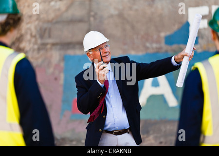 Businessman using walkie-talkie on site Stock Photo