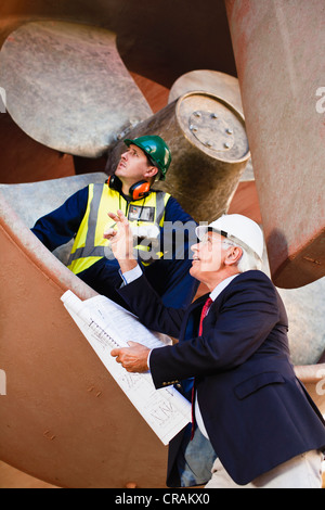 Workers talking in propeller on dry dock Stock Photo