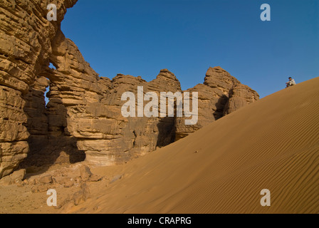 Woman in front of a rock arch in the desert near Tikoubaouine, Algeria, Africa Stock Photo