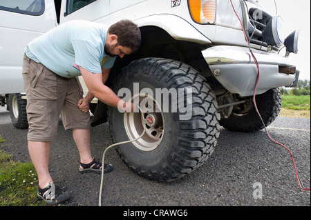 Super jeep driver checking the tire pressure, Iceland, Europe Stock Photo