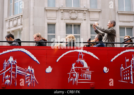 Oxford Street, London.  Tourists taking a sightseeing ride on one of London's open-top, double-decker bus tours Stock Photo