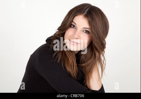Young woman with long hair wearing a long black jumper, portrait Stock Photo