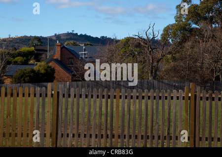 View of house and trees with wooden fence in the foreground, Tasmania, Australia Stock Photo