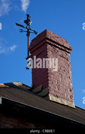 Weather vane and chimney on rooftop against blue sky, Tasmania, Australia Stock Photo