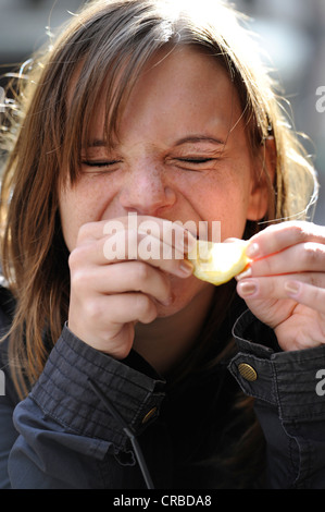 Young woman biting into lemon and laughing, Paris, France, Europe Stock Photo