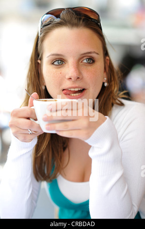 Young woman drinking coffee, holding coffee cup, cafe, Paris, France, Europe Stock Photo