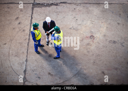 Workers with blueprints on dry dock Stock Photo