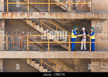 Workers talking on steps on dry dock Stock Photo