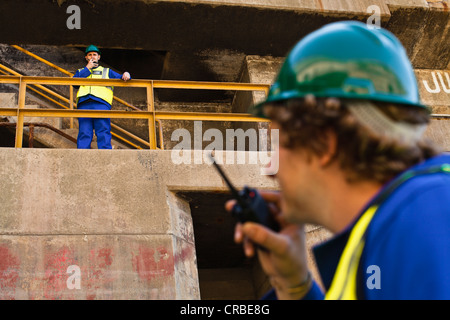 Workers using walkie talkies on dry dock Stock Photo