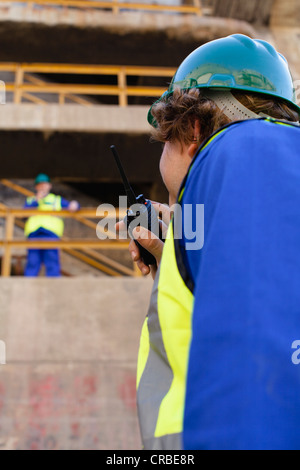 Workers using walkie talkies on dry dock Stock Photo