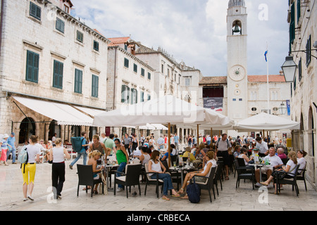 Tourists sitting in an outdoor café, Stradun or Placa street, clock tower, Dubrovnik, Dalmatia, Croatia, Europe Stock Photo