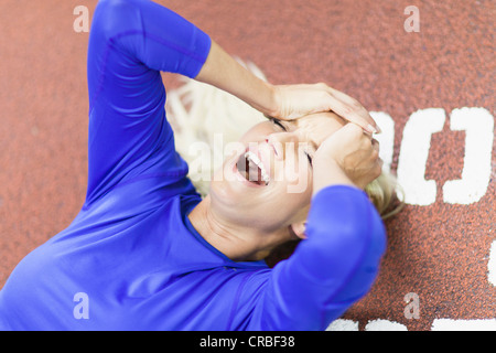 Woman shouting on indoor track in gym Stock Photo