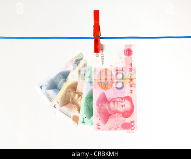 Fan of Chinese yuan or renminbi banknotes, the currency of the People's Republic of China, hanging on a clothesline, symbolic Stock Photo