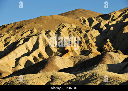 View from Zabriskie Point to eroded rocks discoloured by minerals, evening light, Death Valley National Park, Mojave Desert Stock Photo