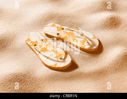 Close up of flip flops in sand Stock Photo