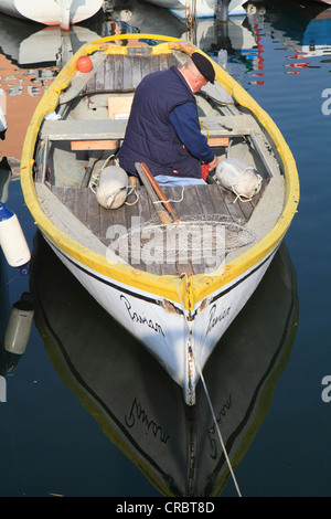 Old fisherman in his boat in the port of Bardolino on Lake Garda, Verona province of Verona, Veneto region, Italy, Europe Stock Photo
